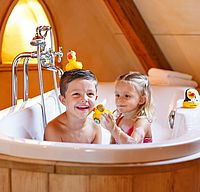 Kinder im Hotel Arthus, Badespaß, Freistehende Badewanne im Holzzuber, kleiner Ritter, kleines Burgfräulein, Quietscheente Schwester Stefanie,Quietscheente König Arthus, Quietscheente Ritter Lancelot